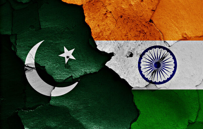 flags of Pakistan and India painted on cracked wall